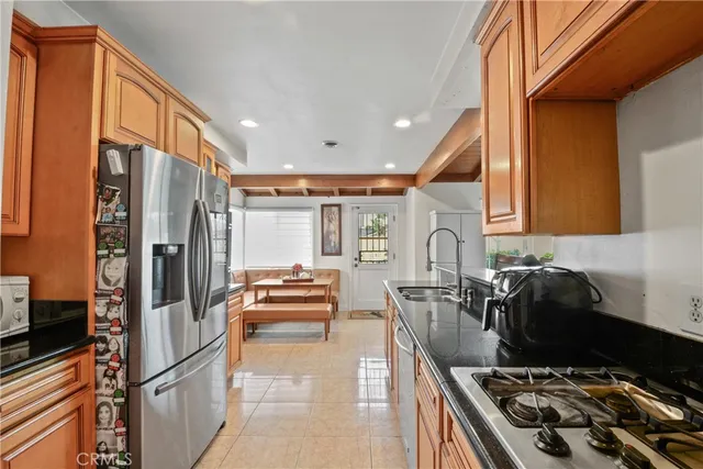 a kitchen with stainless steel appliances granite countertop a stove refrigerator and a sink