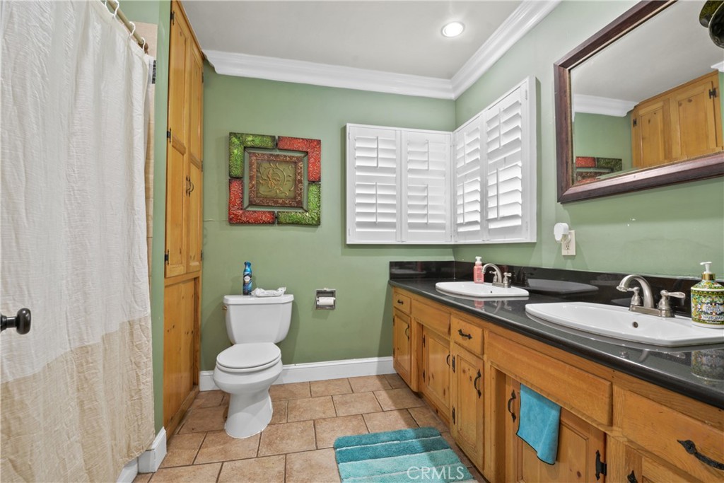 627 West Front Street Covina, CA 91722 - Photo 10 of 16 a bathroom with a granite countertop toilet sink and mirror