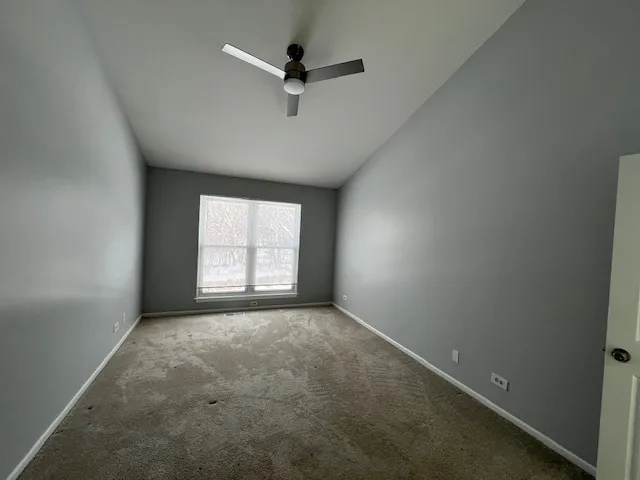 an empty room with a window and a fan