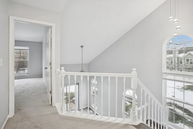 a view of staircase with white walls and railing