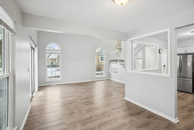 a view of an empty room with window and wooden floor