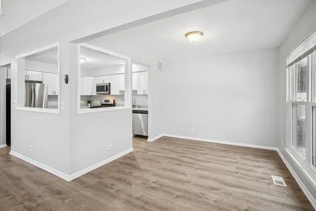 a view of a kitchen with wooden floor and electronic appliances