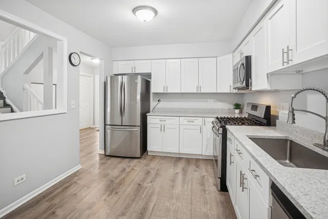 a kitchen with a refrigerator sink and cabinets