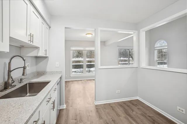 a kitchen with a sink cabinets and wooden floor