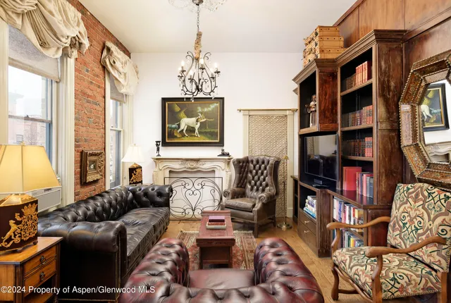 a living room with furniture a flat screen tv and a window