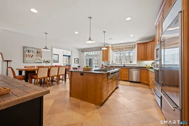 a large kitchen with kitchen island a large counter space a sink appliances and cabinets