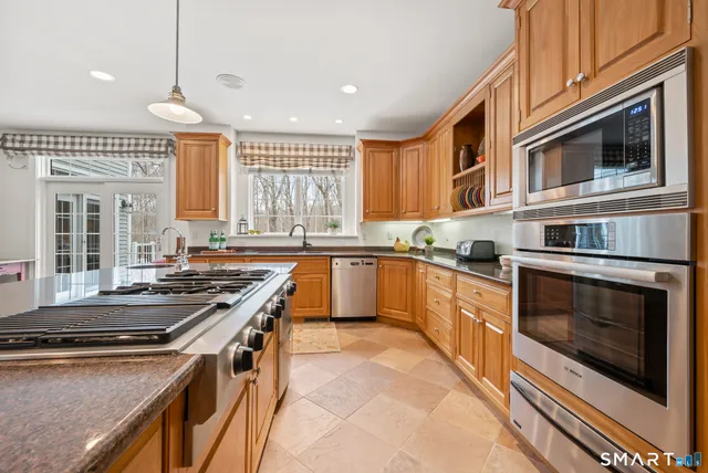 a kitchen with stainless steel appliances granite countertop a stove and a sink