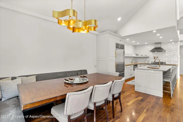 a kitchen with a table chairs and a wooden floor