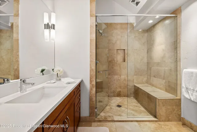 a bathroom with a double vanity sink a toilet a mirror and shower