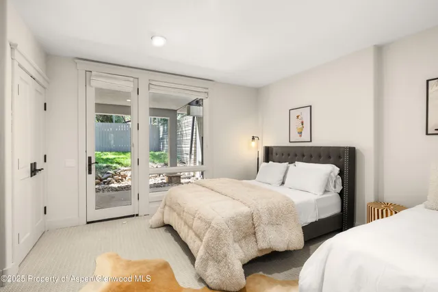 a bedroom with two beds and painted wall next to a window