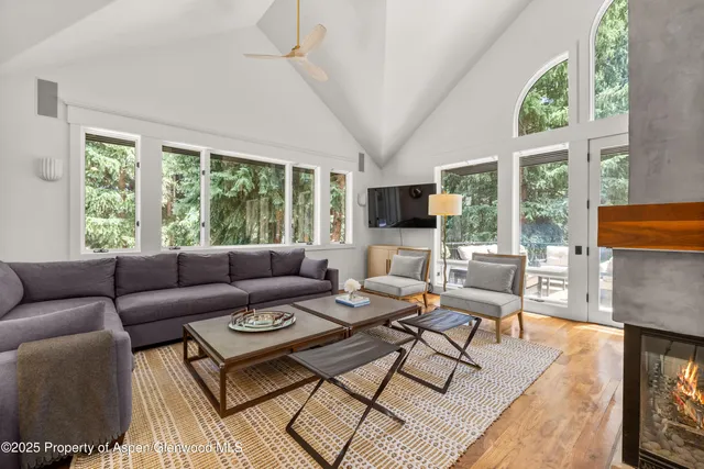 a living room with furniture a flat screen tv and a large window