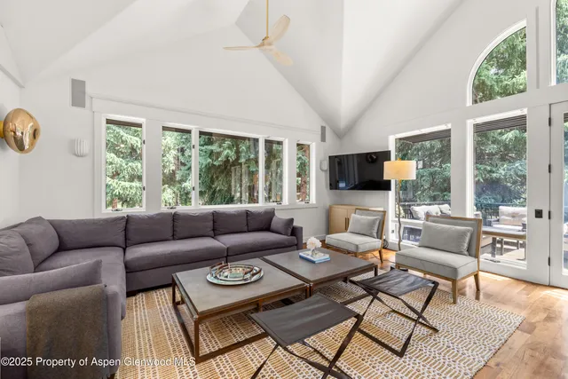 a living room with furniture a flat screen tv and a large window