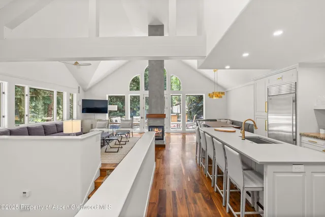 a large white kitchen with a large window and stainless steel appliances