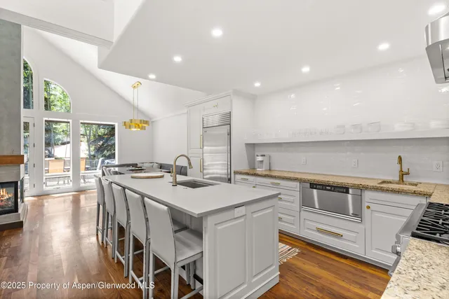 a kitchen with stainless steel appliances granite countertop a sink stove and wooden floor