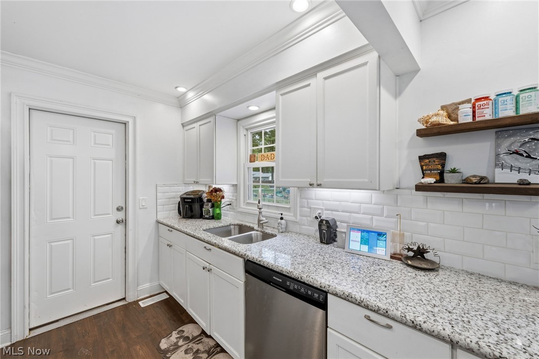 6472 Southgrove Road Mentor, OH 44060 - Photo 16 of 37 Kitchen featuring white shaker-style cabinetry, a stainless steel dishwasher, a dual-basin sink, and granite
countertop