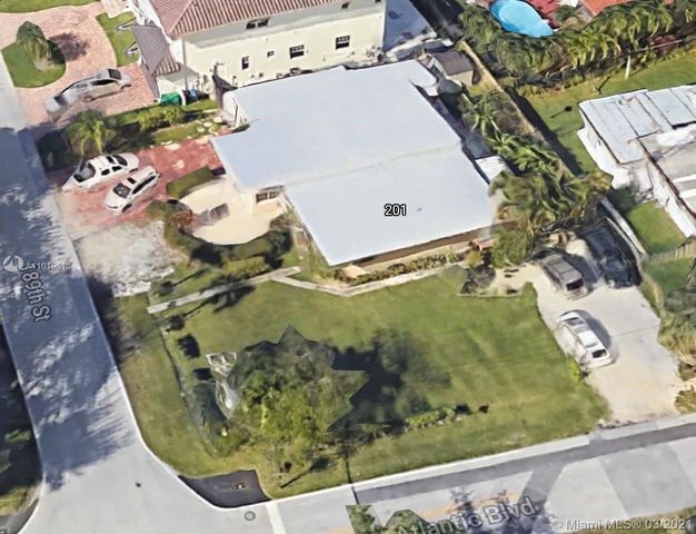 an aerial view of a wooden house with a yard