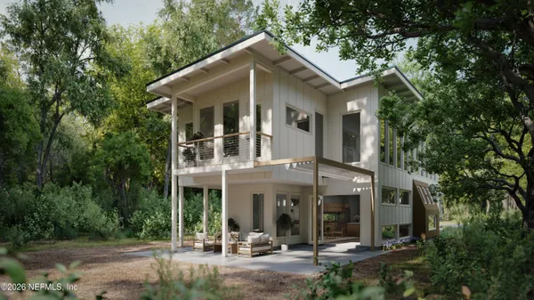 a view of a white house with large windows and a small yard