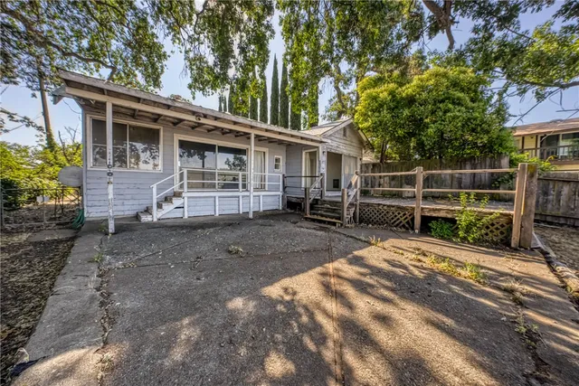 a view of a house with backyard and sitting area