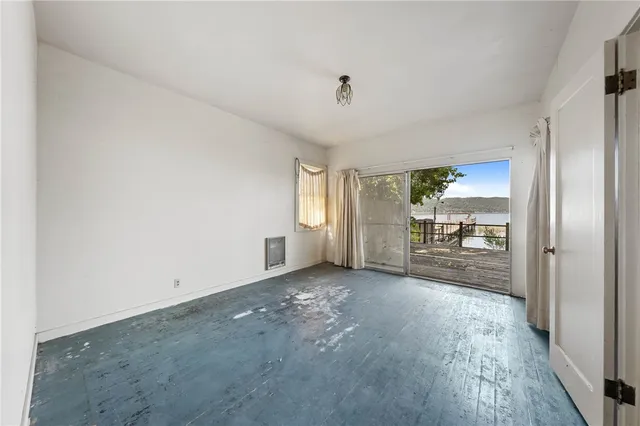 a spacious bedroom with a bed and a flat screen tv