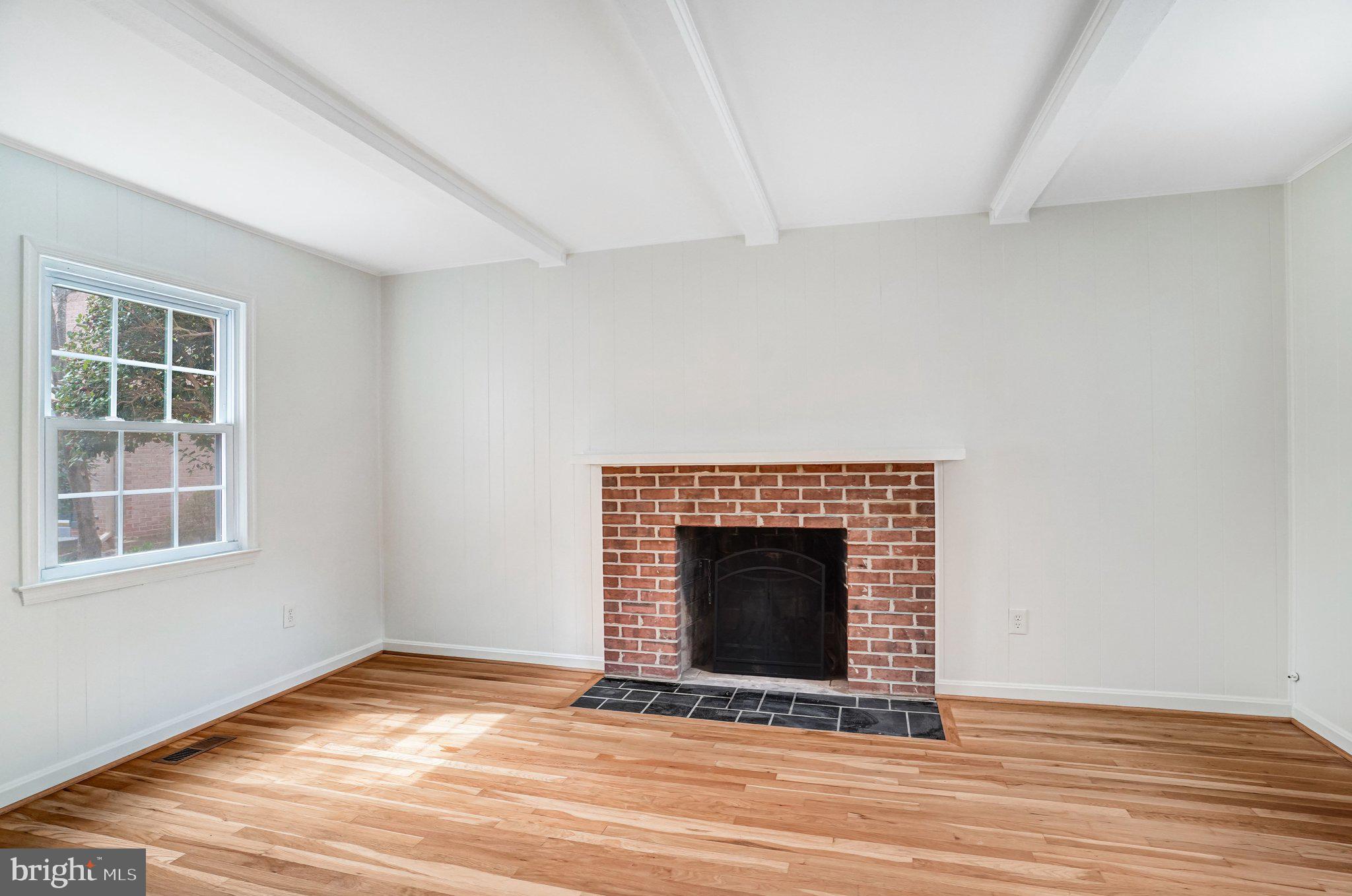 9752 Cardinal Road Fairfax, VA 22030 - Photo 14 of 37 a view of an empty room with wooden floor fireplace and a window