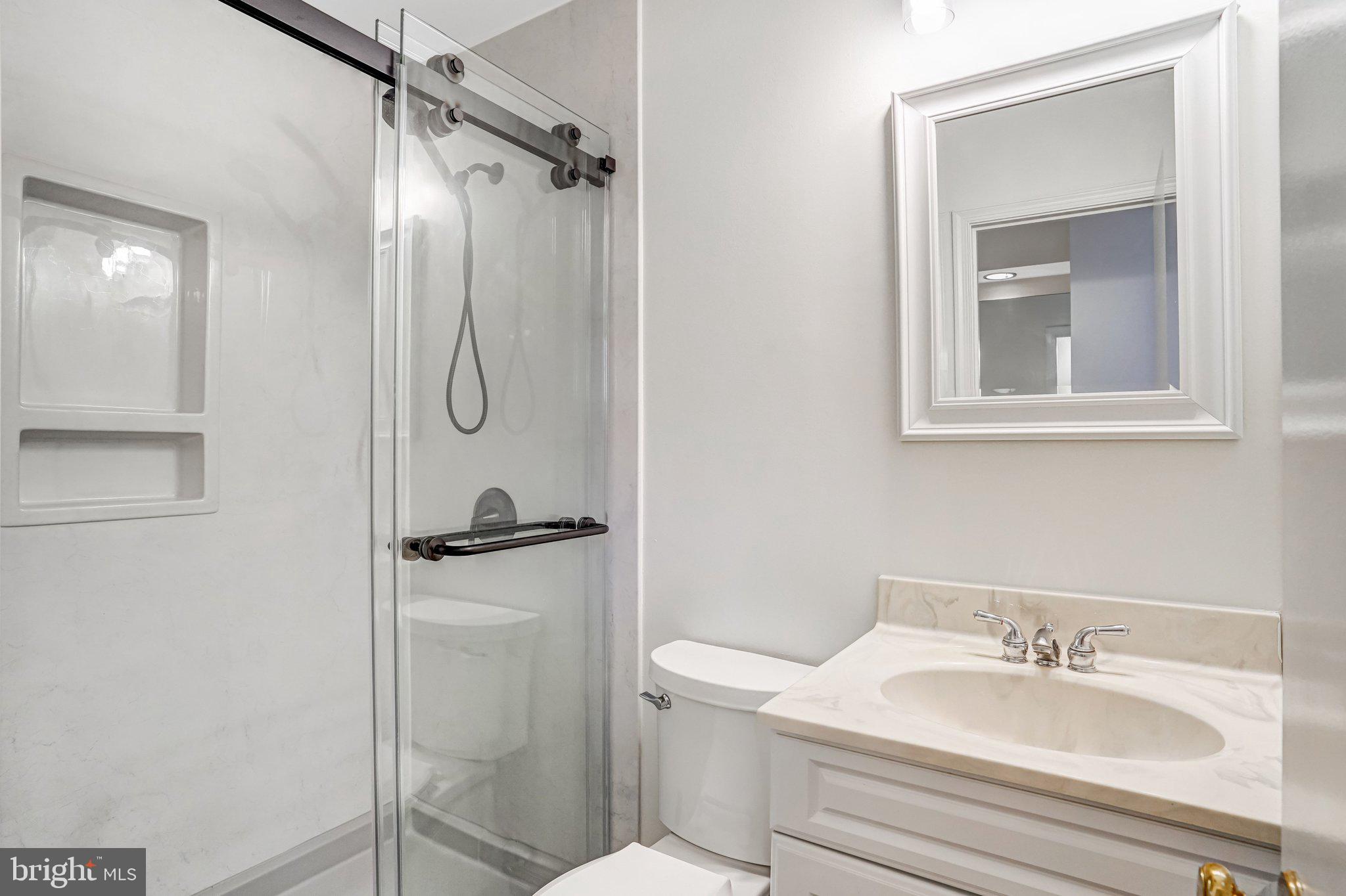 9752 Cardinal Road Fairfax, VA 22030 - Photo 19 of 37 a bathroom with a granite countertop sink toilet and shower