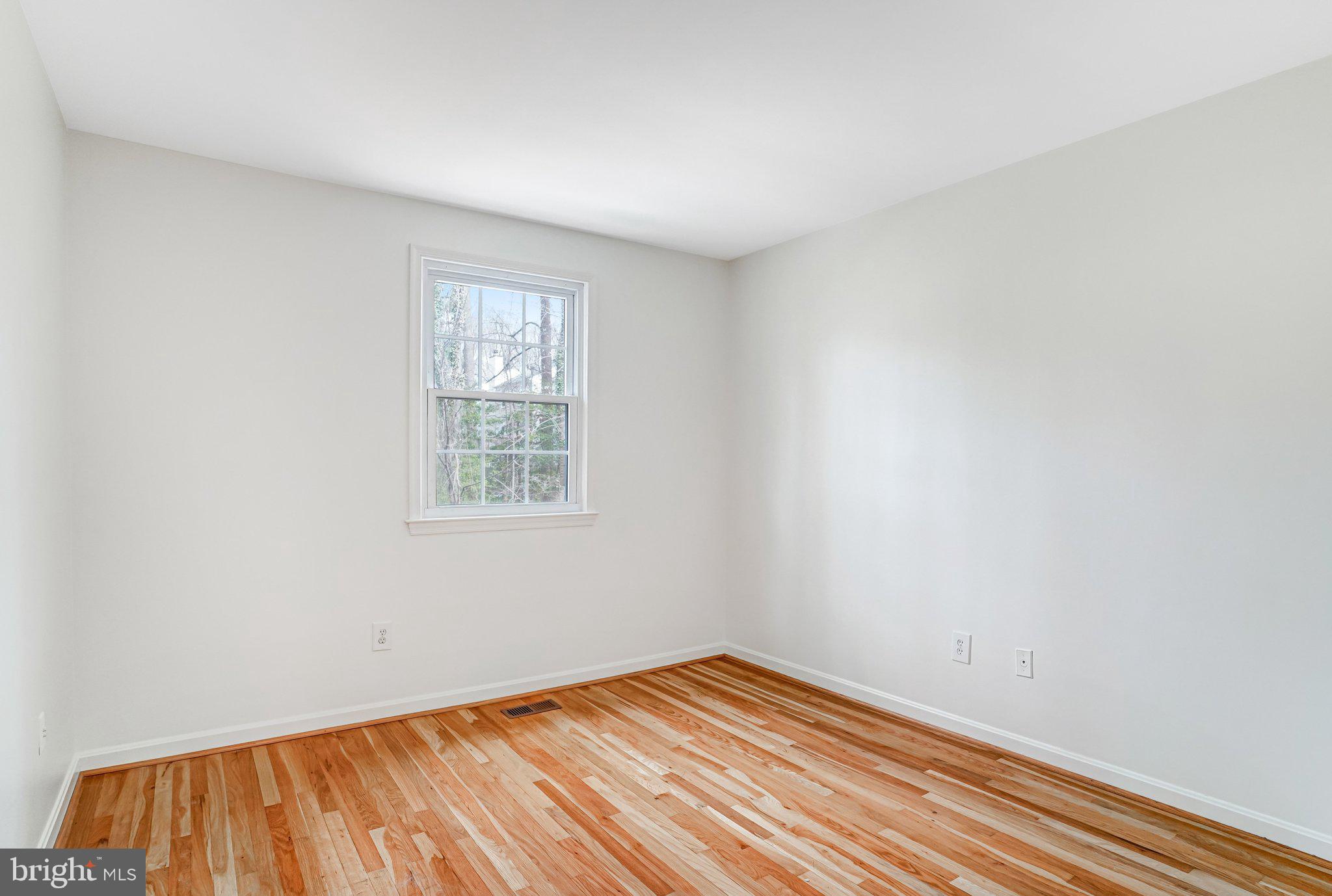 9752 Cardinal Road Fairfax, VA 22030 - Photo 22 of 37 a view of an empty room with wooden floor and a window
