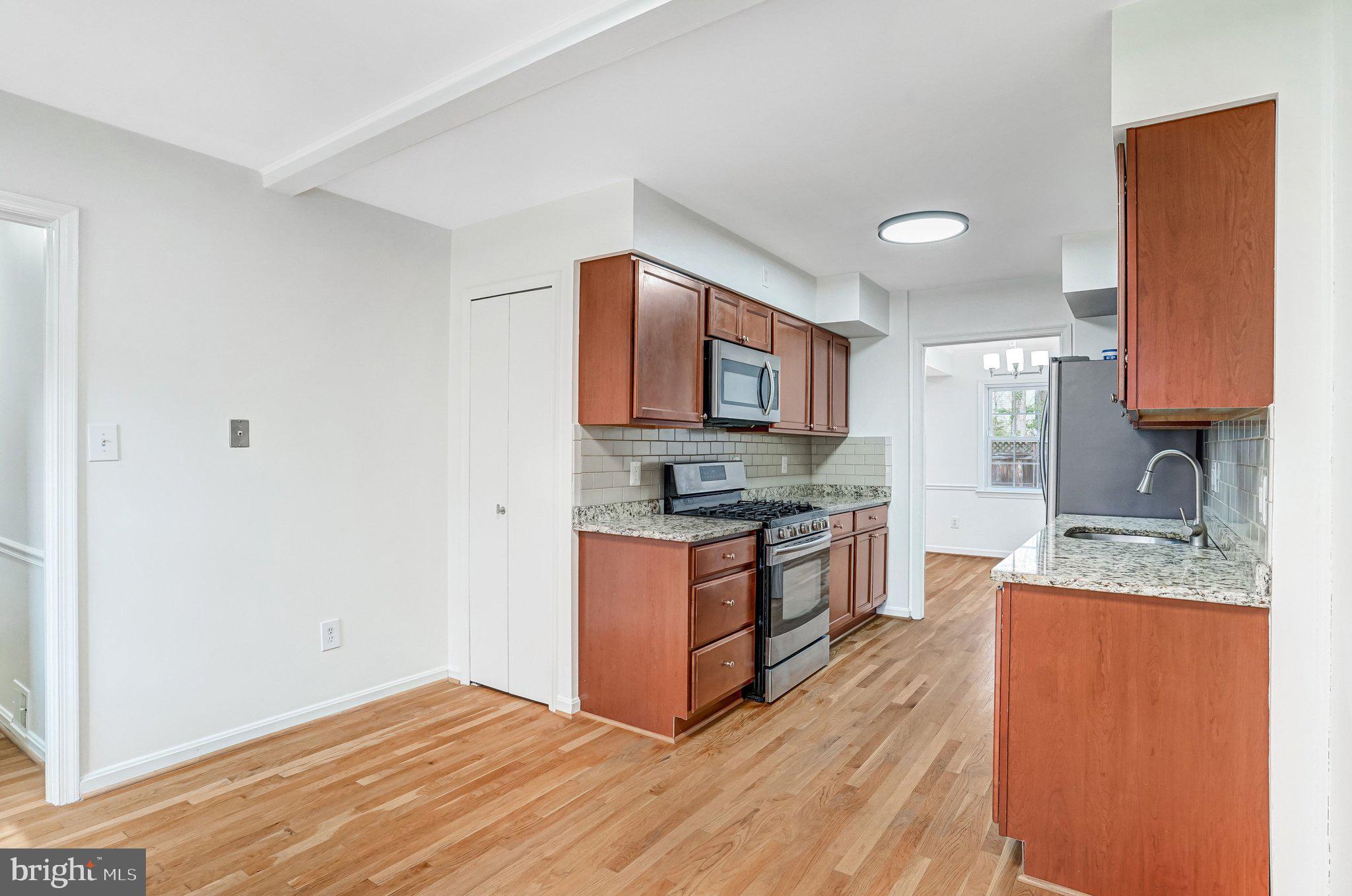 9752 Cardinal Road Fairfax, VA 22030 - Photo 5 of 37 a kitchen with stainless steel appliances granite countertop a stove a sink and a microwave