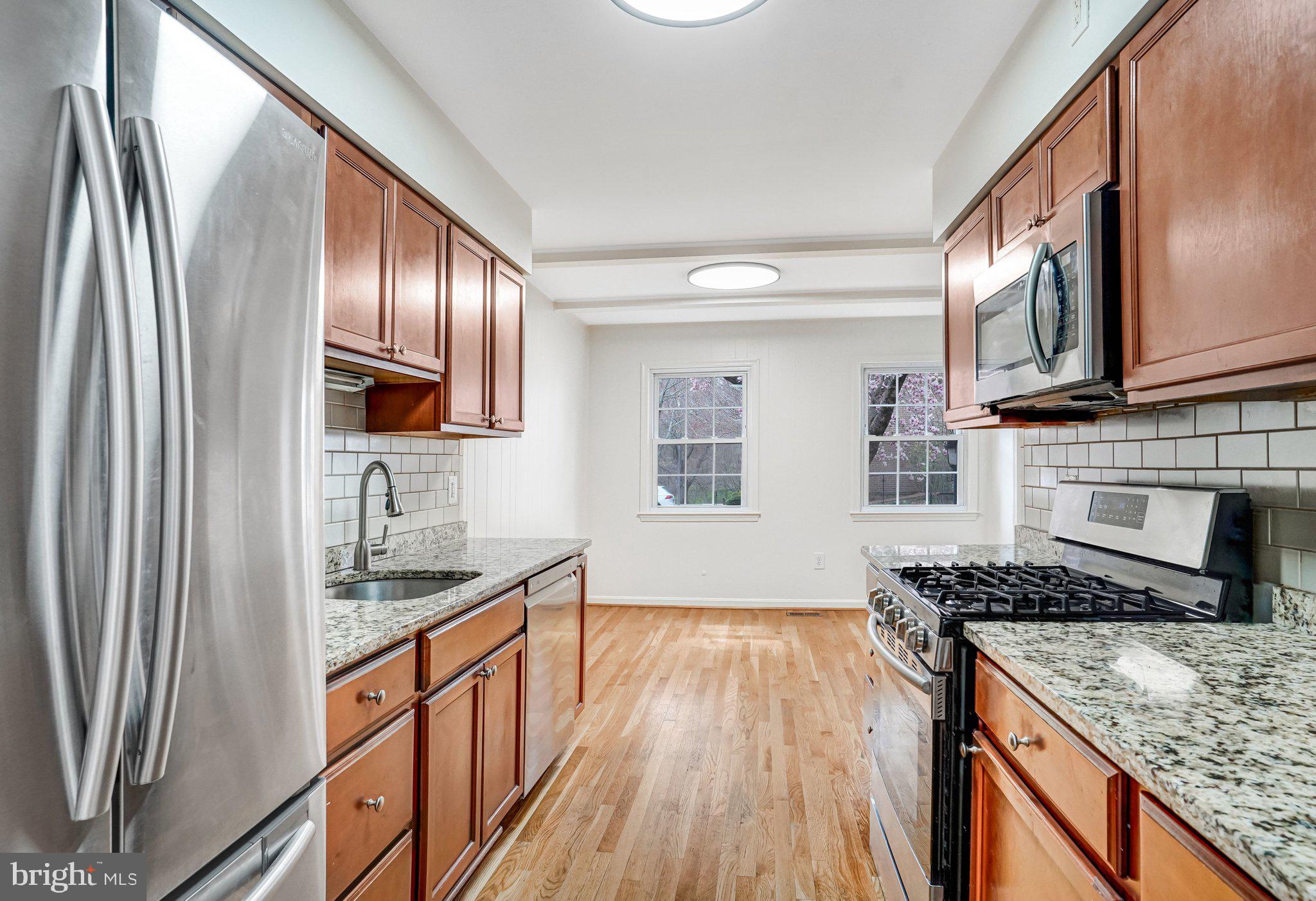 9752 Cardinal Road Fairfax, VA 22030 - Photo 6 of 37 a kitchen with stainless steel appliances granite countertop a refrigerator a stove top oven a sink and dishwasher