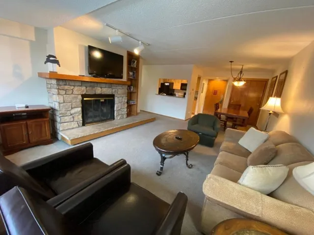 a living room with furniture a flat screen tv and a fireplace