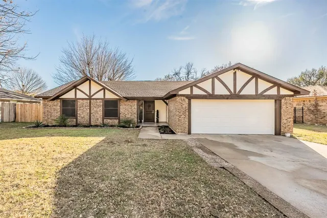 a view of a house with a yard and wooden fence