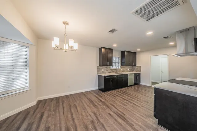 a large kitchen with kitchen island a sink stainless steel appliances and cabinets