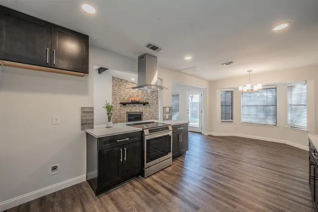 a kitchen with stainless steel appliances a sink a stove a refrigerator and wooden floor