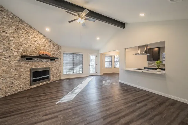 a view of empty room with wooden floor and fireplace