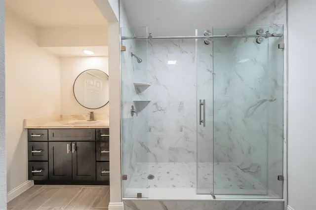 a bathroom with a shower a mirror and a sink