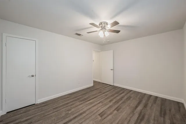 a view of empty room with wooden floor