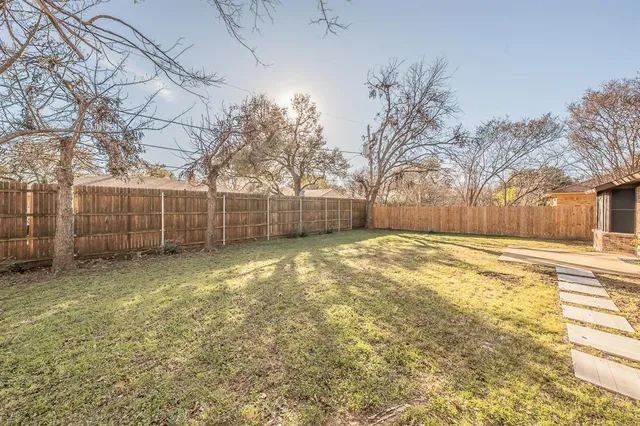 a view of a yard with a house and a large tree