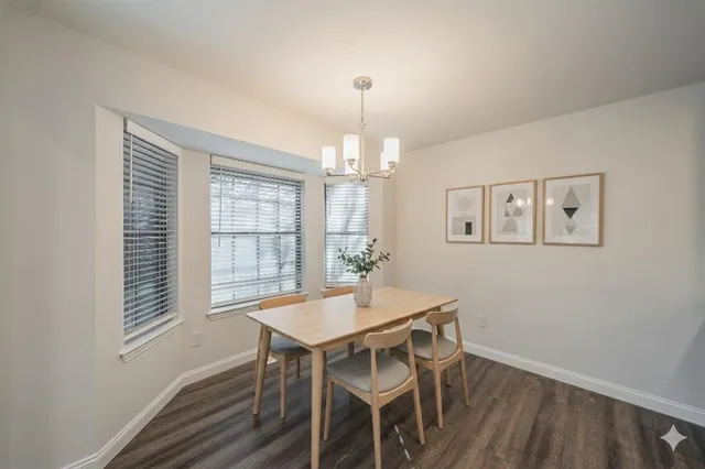 a dining room with wooden floor and chandelier