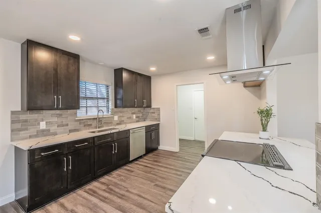 a large white kitchen with a sink and a large mirror