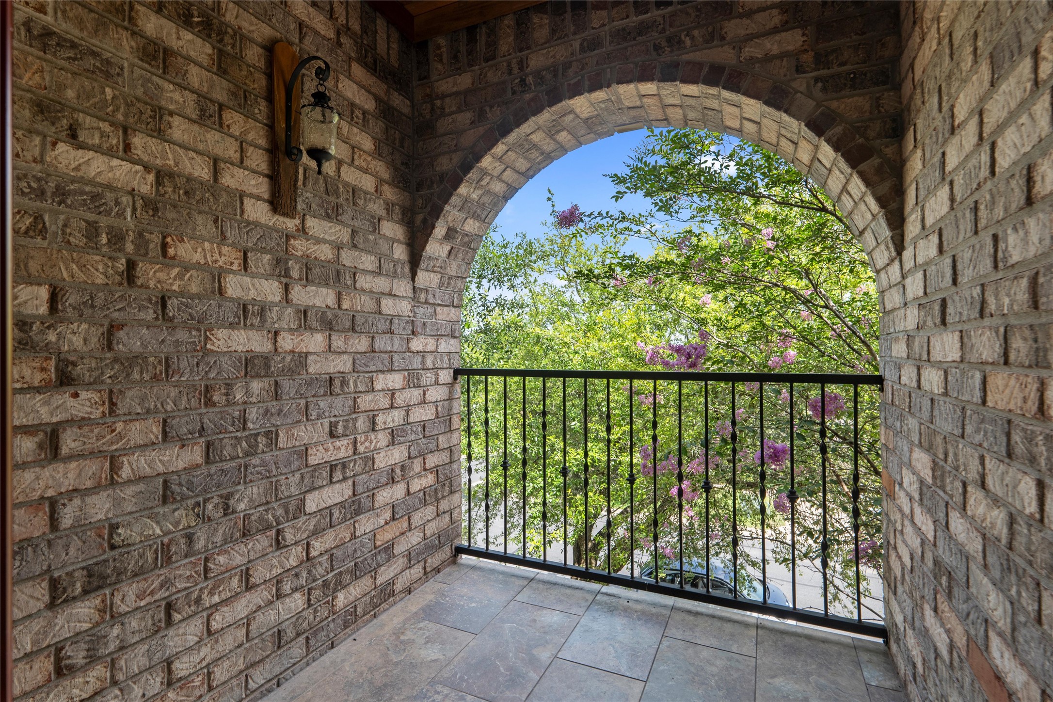 7000 Colberg Court Austin, TX 78749 - Photo 30 of 40 An inviting brick balcony, complete with a wrought iron railing, overlooks a verdant landscape.