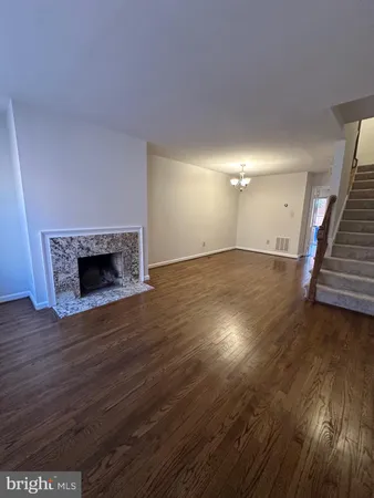 an empty room with wooden floor and fireplace