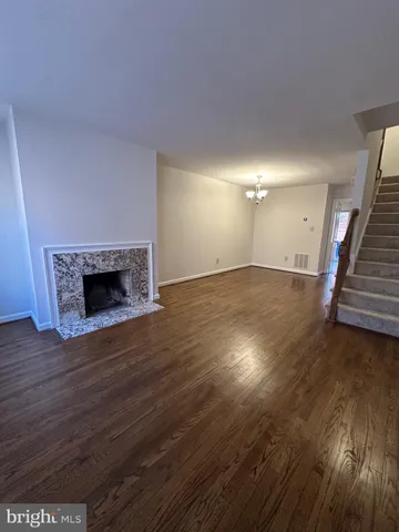an empty room with wooden floor and fireplace