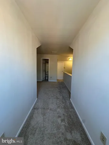 a view of a hallway with an empty room and a window