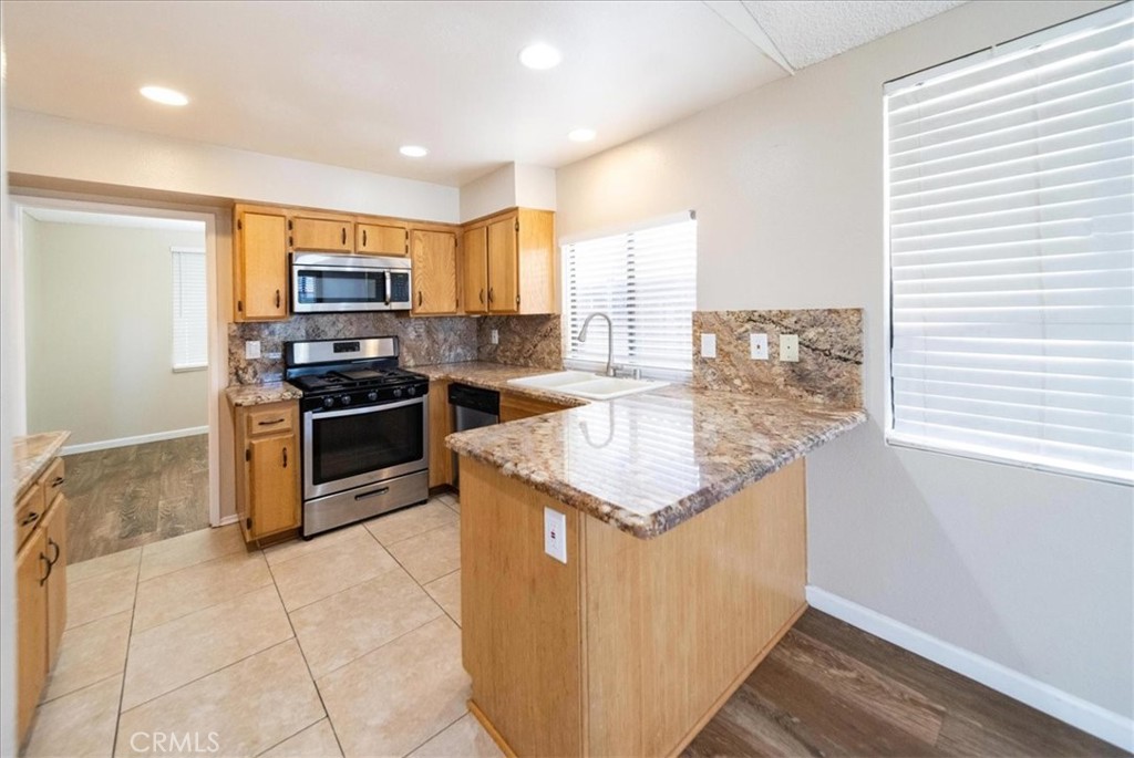 39739 Old Carriage Road Murrieta, CA 92563 - Photo 12 of 31 a kitchen with stainless steel appliances granite countertop a stove a sink and a refrigerator