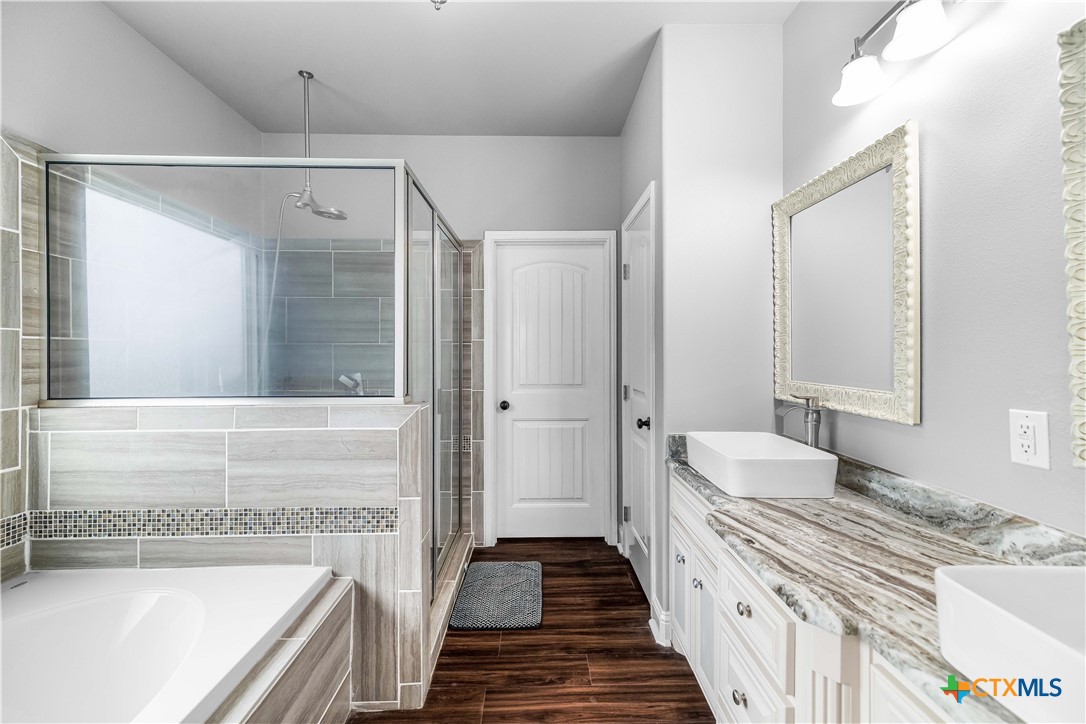204 James Street Inez, TX 77968 - Photo 18 of 35 a bathroom with a granite countertop double vanity sink a mirror and a bathtub