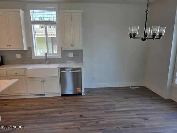 a view of a kitchen with wooden floor and a window