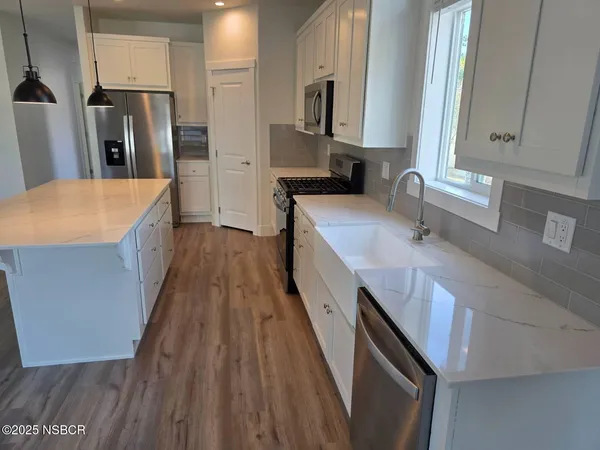 a kitchen with stainless steel appliances a sink stove and refrigerator