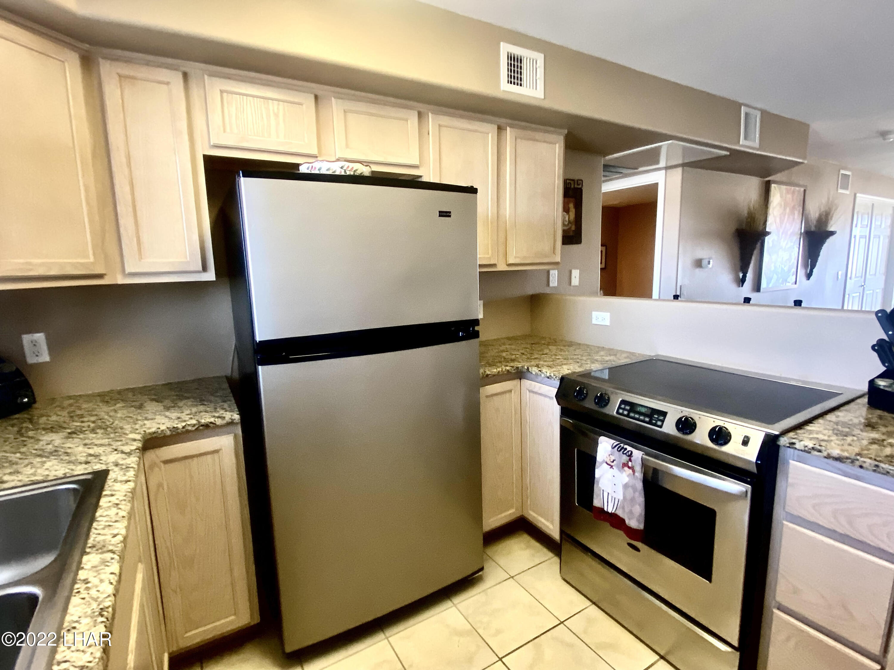 94 London Bridge Road, Unit 507 Lake Havasu City, AZ 86403 - Photo 6 of 13 a kitchen with granite countertop a refrigerator and a sink