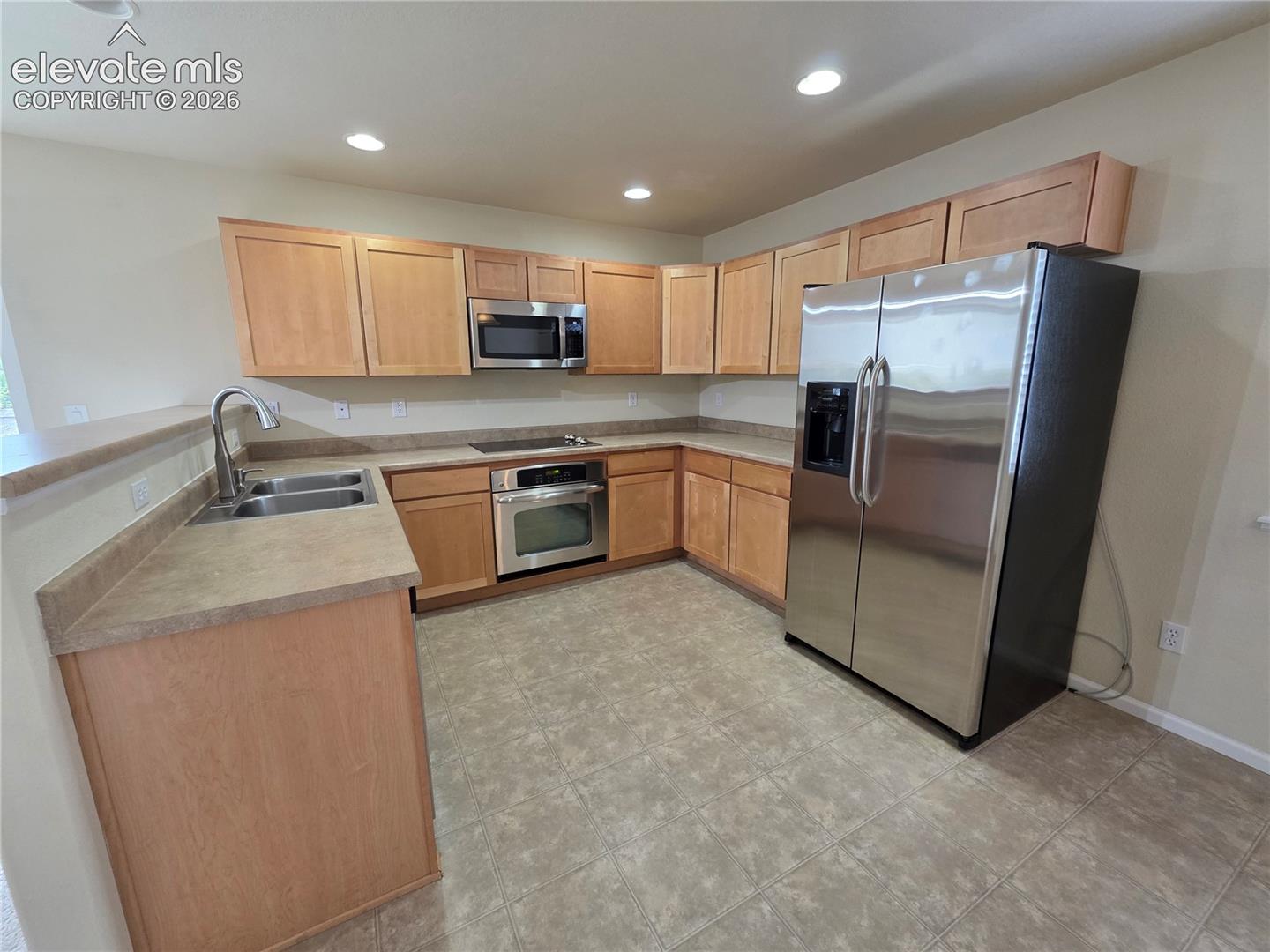 874 Diamond Rim Drive Colorado Springs, CO 80921 - Photo 8 of 28 Kitchen featuring wood-finish cabinetry, stainless steel appliances, a double basin sink with a high-arc faucet, and recessed lighting