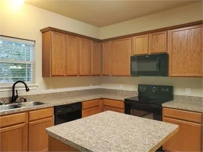 a kitchen with a sink dishwasher a stove and a microwave oven with cabinets