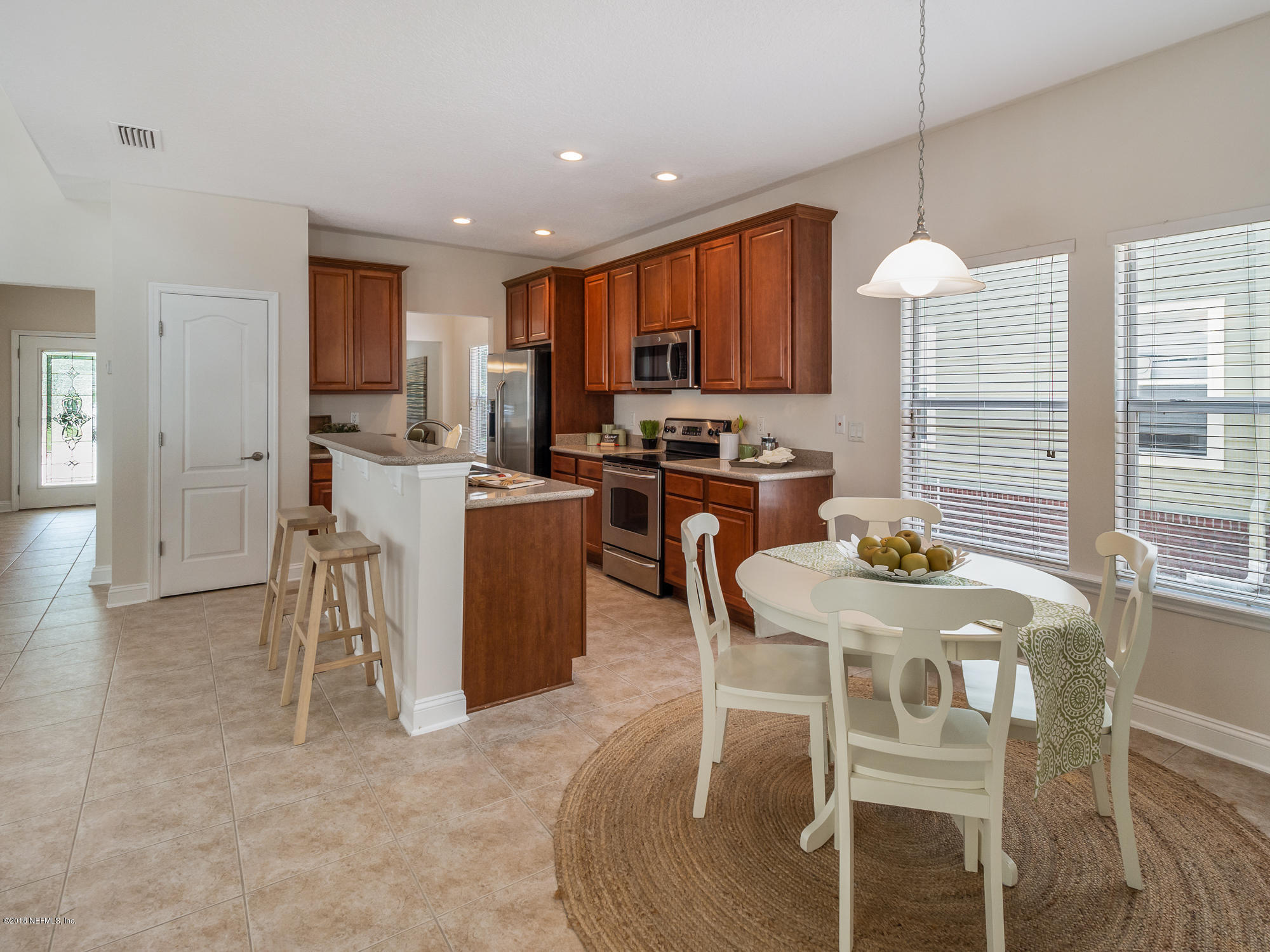 3716 Chasing Falls Road Orange Park, FL 32065 - Photo 9 of 31 a kitchen with a table chairs refrigerator and microwave